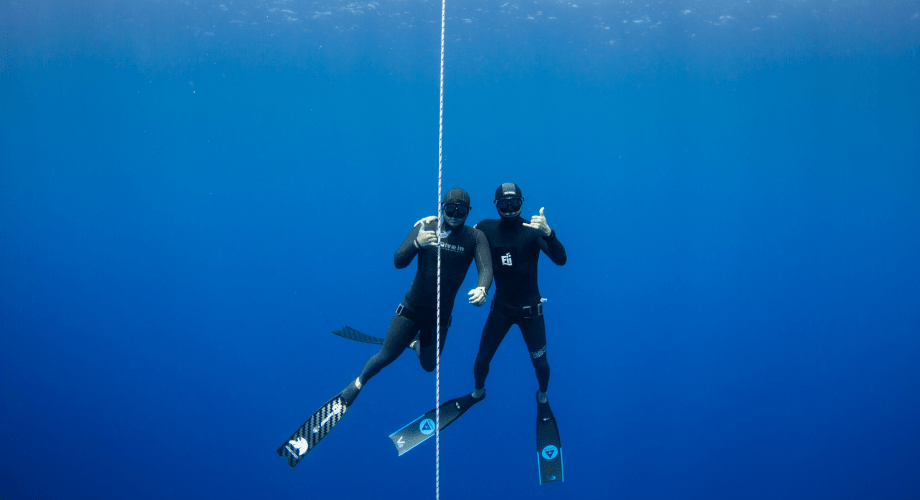 Two freedivers practicing together underwater